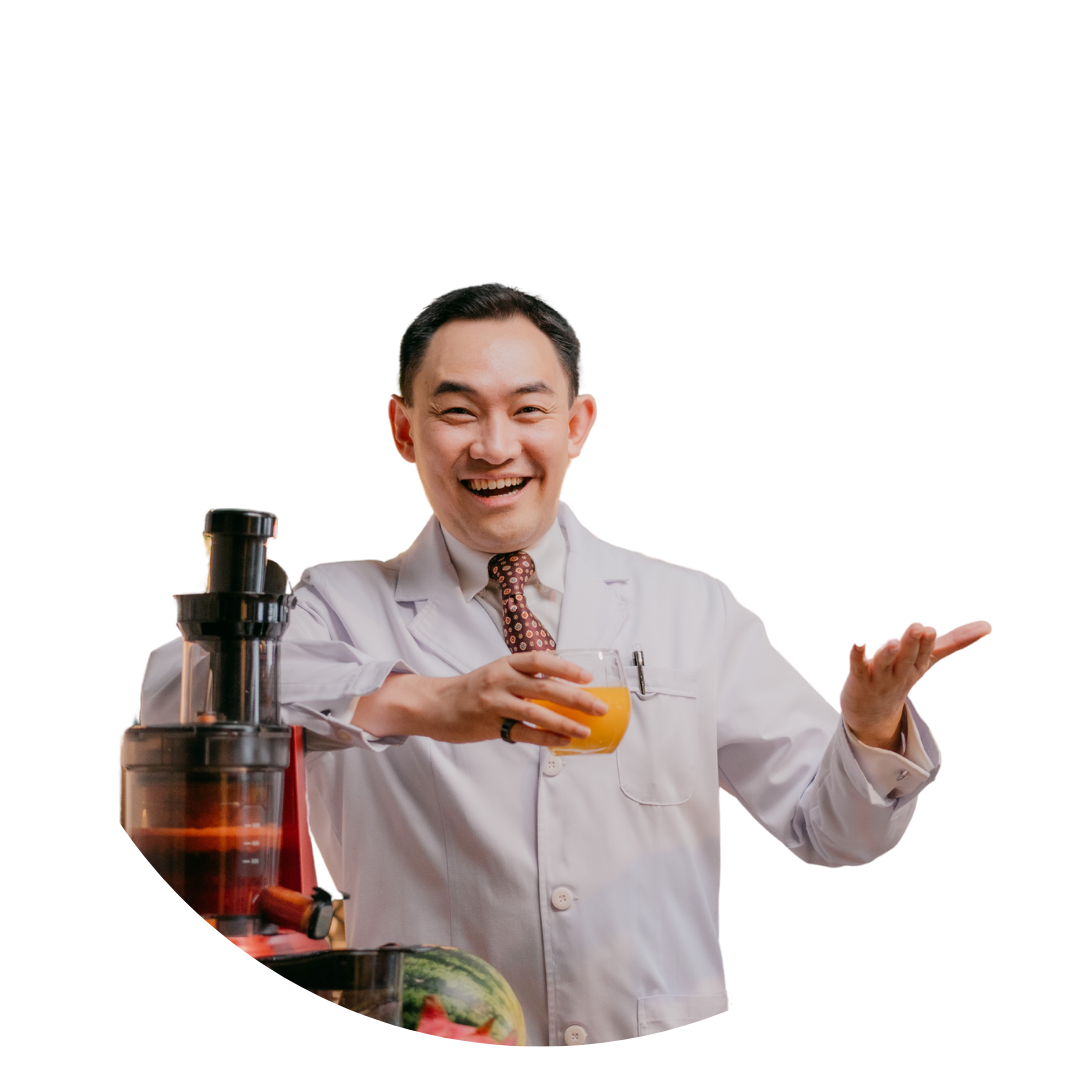 Dr. Mark Leong holding a glass beside a juicer